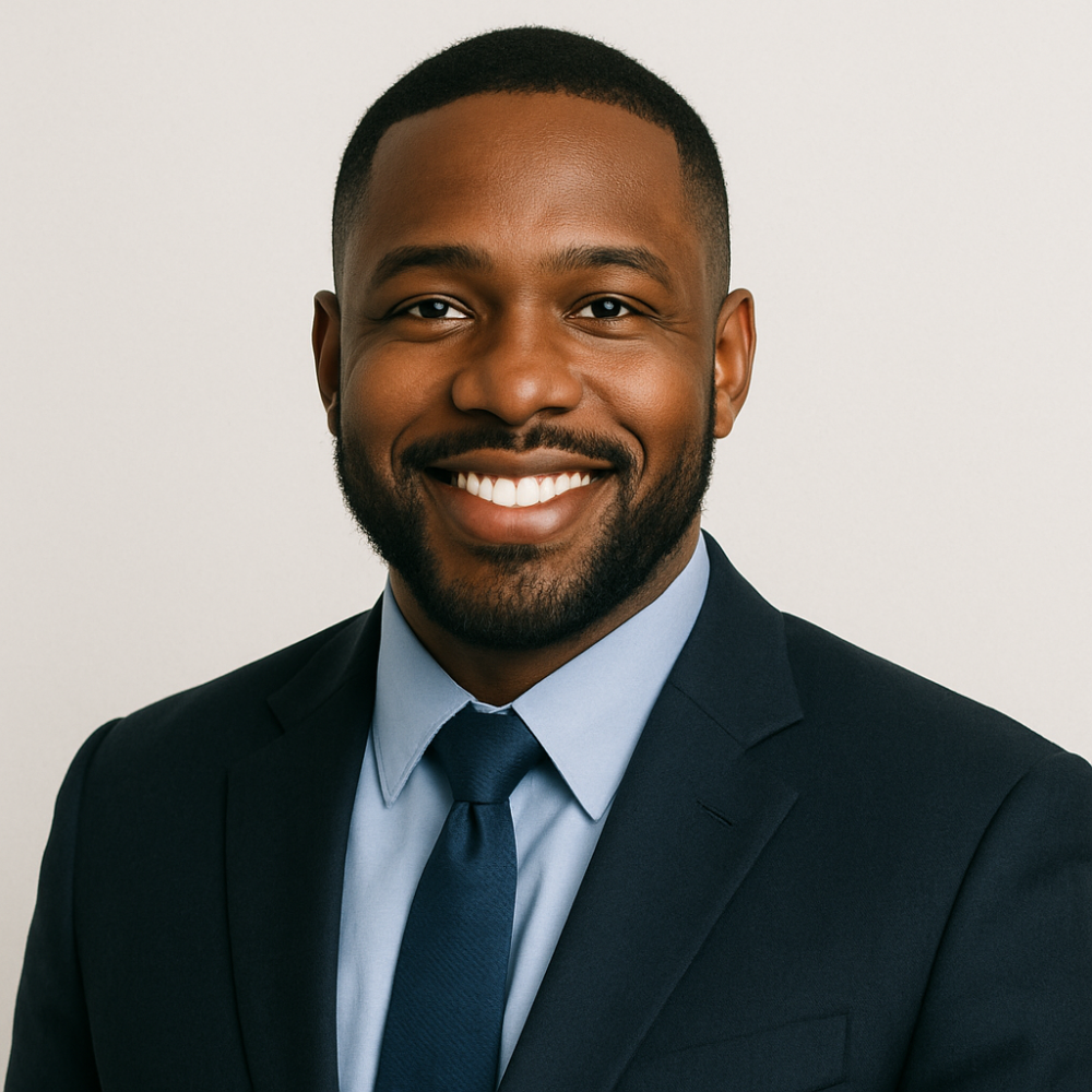 Smiling man in suit and tie against plain background, professional headshot.