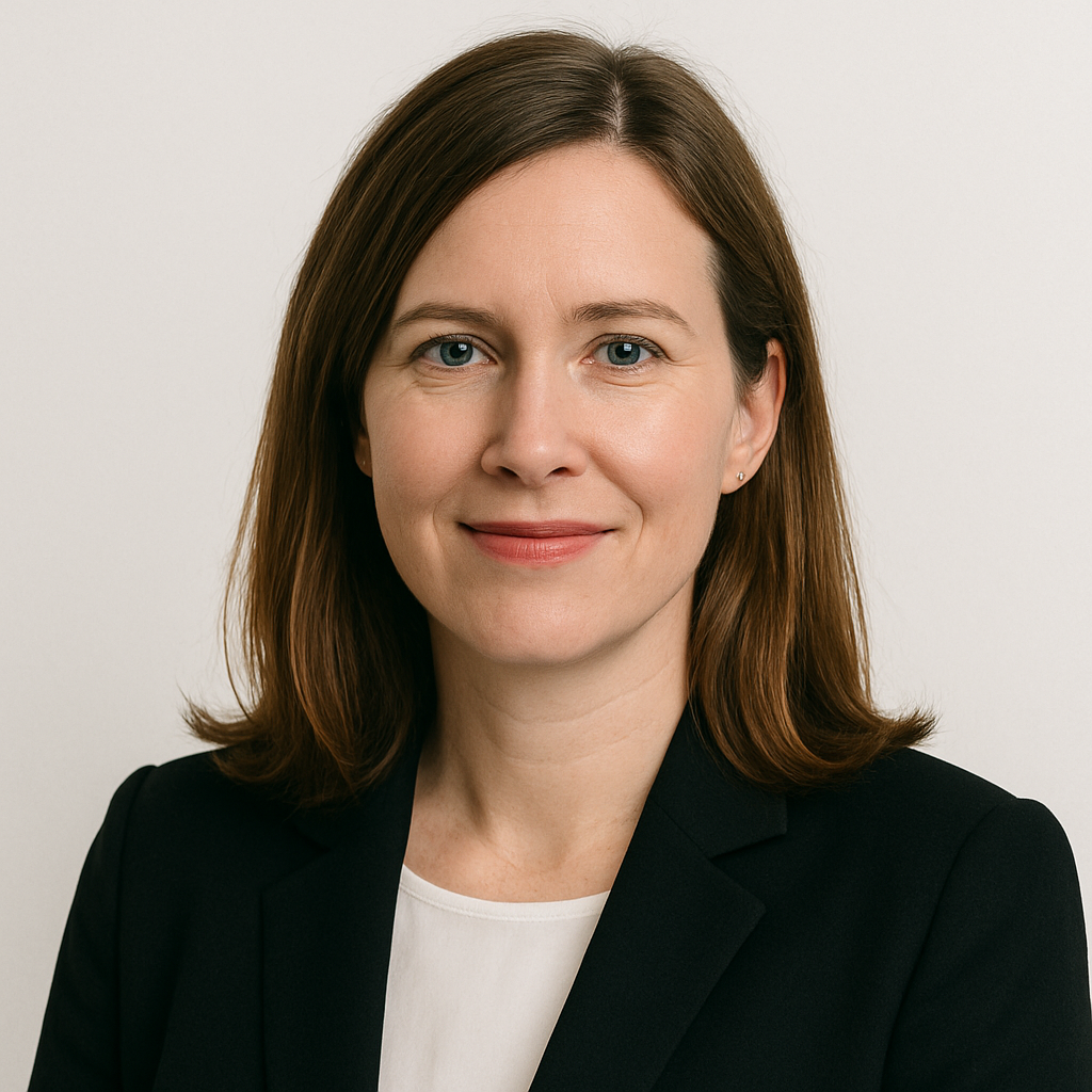 Professional woman in a black blazer smiling against a plain background.