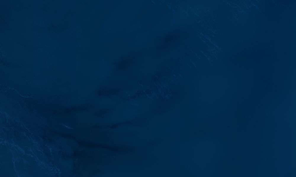 Deep blue ocean surface with subtle ripples, capturing a tranquil marine texture.