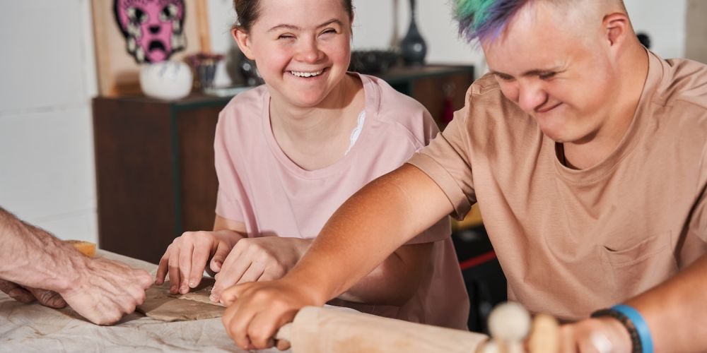 People happily crafting clay sculptures together in a creative class activity.