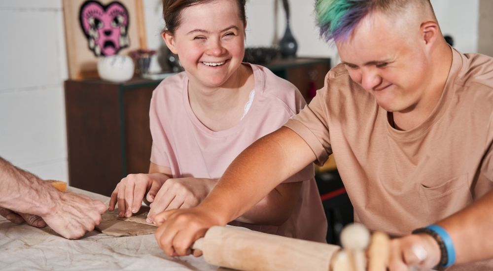 People happily crafting clay sculptures together in a creative class activity.